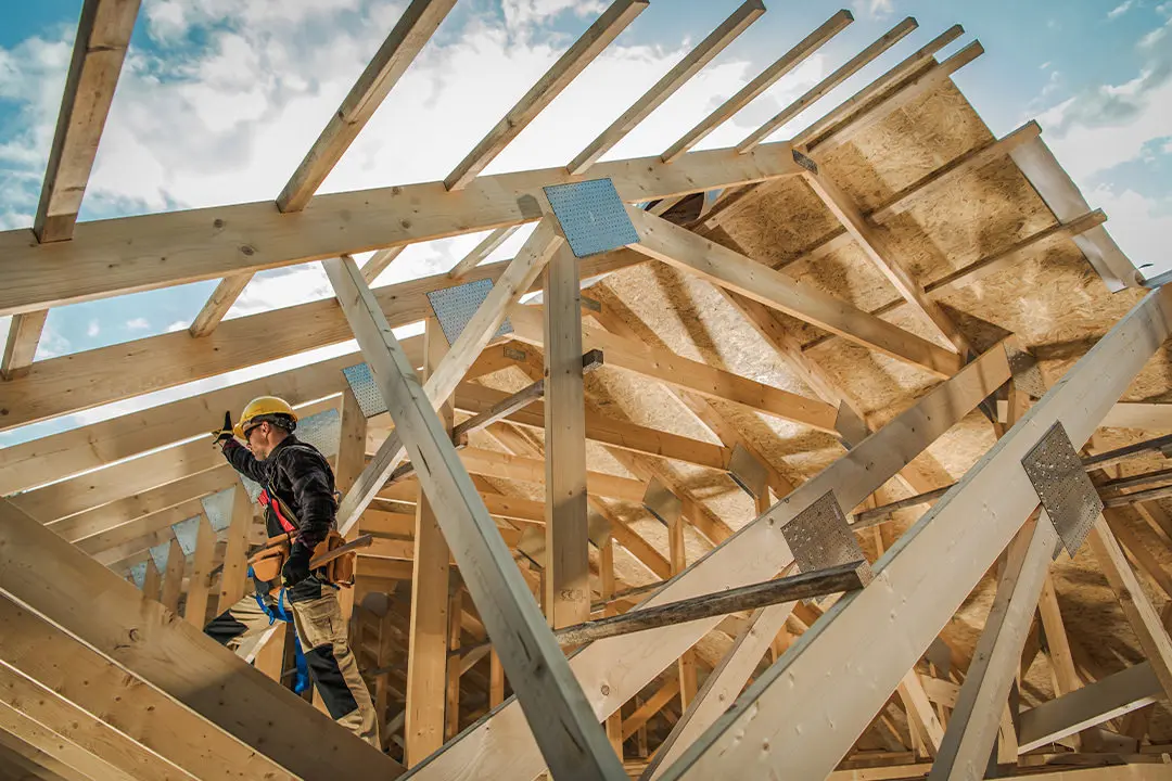 Arbeiter baut Dachstuhl auf