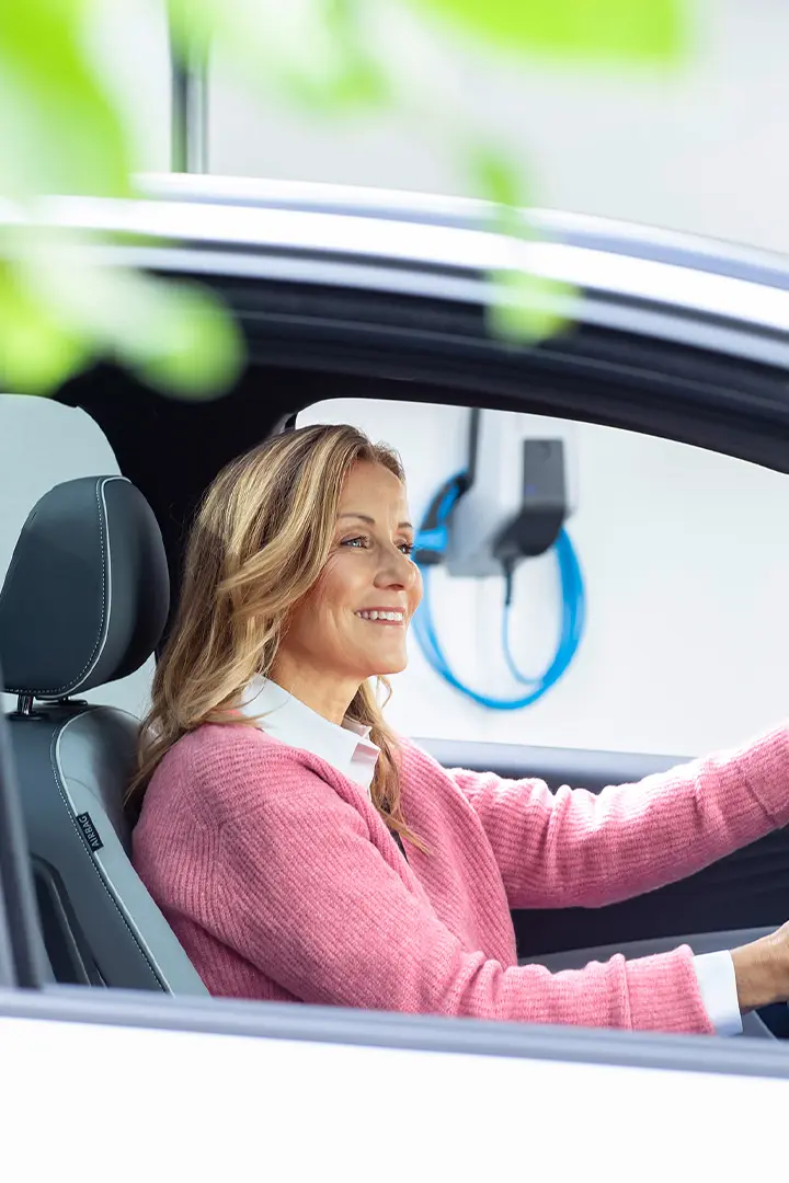 Lächelnde Person sitzt in einem Auto